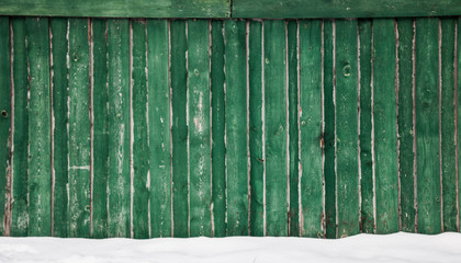 old green fence under the snow
