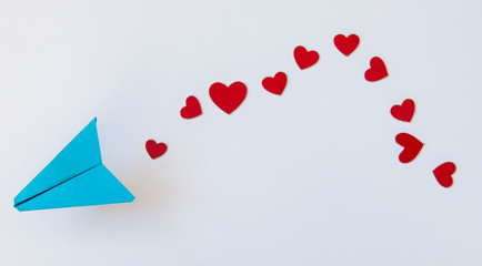 Valentine's Day background. Paper plane with red heart flying on a white background. Greeting card