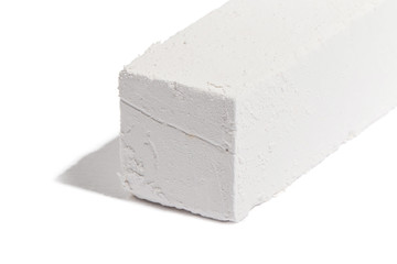 Piece of chalk isolated on white. Pure soft whitish calcite. White, sawn, natural mined chalk, environmentally friendly product. Tasty pica