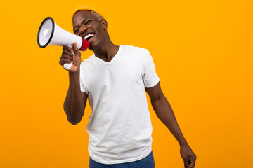 black african man singing in a megaphone on isolated orange background