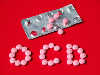 “OCD” Spelled with Pink Pills on Red Background with Blister Pack – Mental Health and...