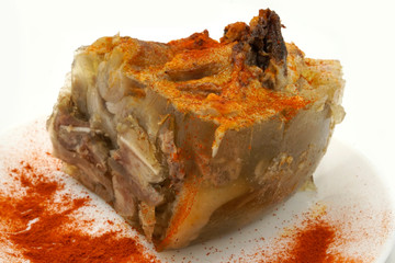 Traditional Romanian homemade pork trotter jelly dish called piftie. Jellied pork aspic made with pork meat served with paprika and fresh parsley.