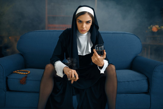 Sexy nun in a cassock sitting spreading her legs