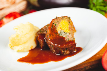 Zrazy cutlets with minced meat, rice and eggs served with mashed potatoes on white plate.