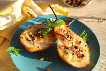 Baked pears with dor blue cheese on a blue plate
