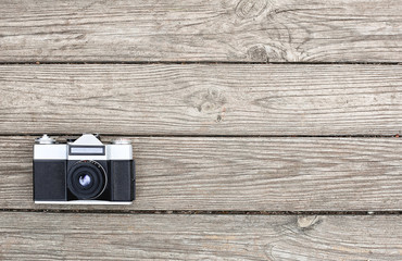 Retro camera on wooden background top view
