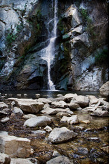 A tranquil waterfall in California with rocks in the foreground