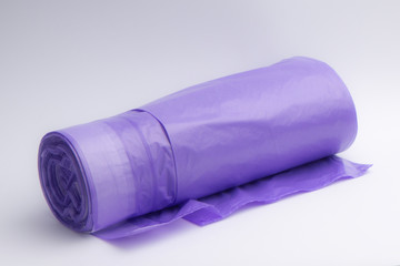 Plastic trash bags with puffs in a large roll of purple. Household items that pollute the environment.