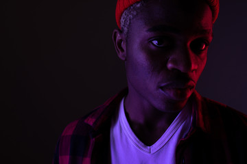Closeup portrait of a stylish handsome african black man in neon light