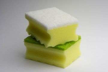 Two yellow-green foam sponge for washing dishes on a white background.