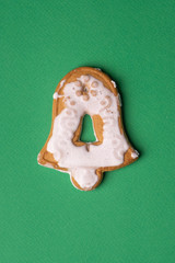 Handmade cookies in glaze in the form of Christmas toys on a green background.