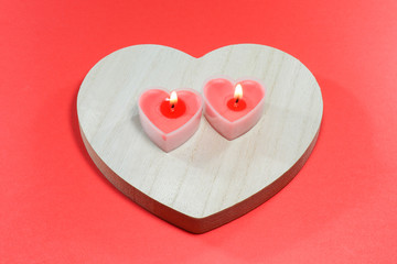 Naklejka na ściany i meble pink candles in the form of a heart on a red background for Valentine's day