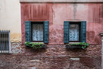 Obraz na płótnie Canvas Vintage european style red building wall and green windows in Venice, Italy
