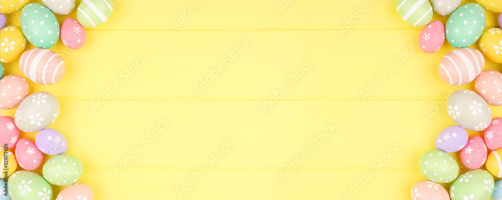 Poster easter banner with pastel colored egg double side border over a yellow wood background. overhead vie
