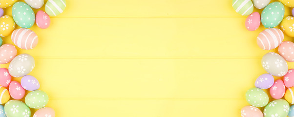 Easter banner with pastel colored egg double side border over a yellow wood background. Overhead view with copy space.