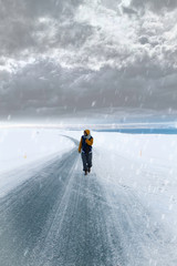 chico caminando por la carretera en un paisaje nevado