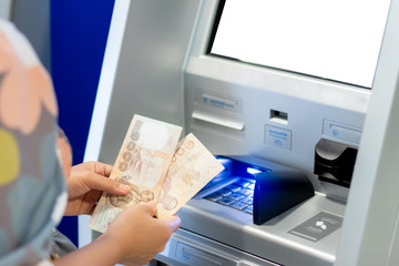Woman counting thai baht withdrawn from ATM