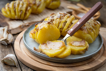 Homemade baked potato with bacon and cheese on wooden table.