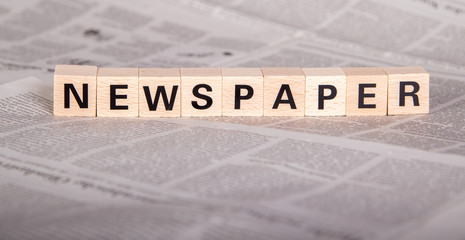 newspaper text on wooden cubes, newspaper as background