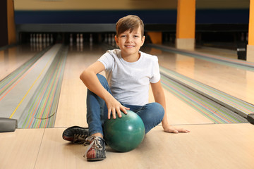 Preteen boy with ball in bowling club