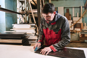 Process of production and manufacture of wooden furniture in furniture factory. Worker carpenter...