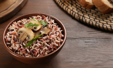 Delicious brown rice in bowl on wooden table