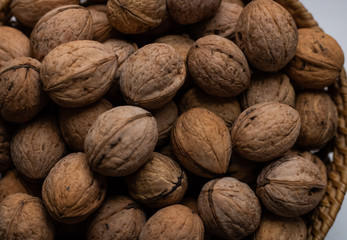 Walnuts close-up. A lot of nuts in a small basket. Background