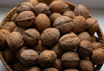 Walnuts close-up. A lot of nuts in a small basket. Background