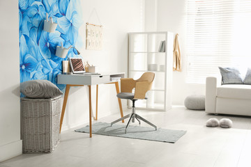 Stylish living room interior with blue flowers painted on wall. Floral pattern