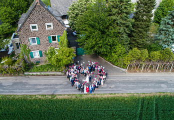 Wedding guests lined up in the shape of heart with bride and groom marriage people - Powered by Adobe