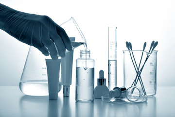 Dermatologist formulating and mixing pharmaceutical skincare, Cosmetic bottle containers and...