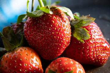  strawberry berries close up on a dark background