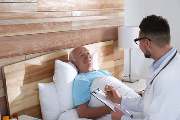 Doctor examining senior patient in modern hospital