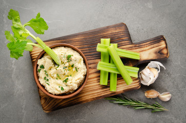 Flat lay view at vegetable Hummus dip dish topped with chickpeas and olive oil served with celery...