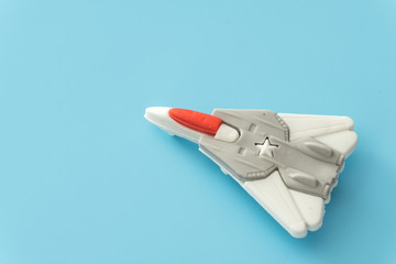 rubber fighter plane toy display on blue background view