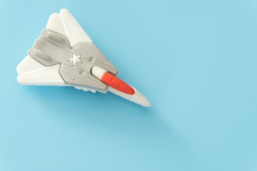 rubber fighter plane toy display on blue background view