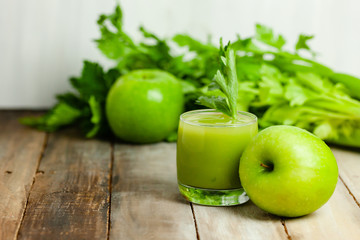 Healthy eating, food and vegetarian diet concept - glass of fresh green apple and celery juice or smoothie. Antioxidant detox beverage. Clean organic ingerdients. Copy space, wooden background.