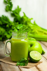 Healthy eating, food and vegetarian diet concept - mason jar of fresh juice or smoothie with apple, celery. Antioxidant detox beverage. Organic ingerdients. Close up, wooden background, copy space