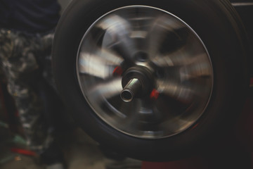 A process of new tire replacement, disc brake on car, repair in garage, automotive service station, mechanic changing a wheel and tires