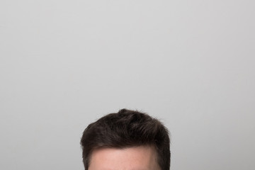 Brunette man with thick hair. Men's head. Studio image men's hairstyle.