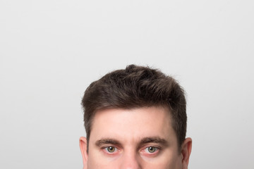 Fototapeta premium Man with gray-green eyes and beautiful hair. Brunette man with gray eyes.
