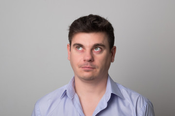 Man looks up studio image. Pretty man with dark hair.