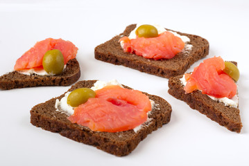 Appetizer, open sandwich with salmon and soft cheese on white background. Traditional Italian or Scandinavian cuisine. Concept of proper nutrition and healthy eating. Flat lay, copy space for text