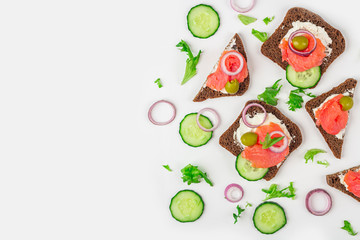 Appetizer, open sandwich with salmon, onion and cucumber on white background. Traditional Italian or Scandinavian cuisine. Concept of proper nutrition and healthy eating. Flat lay, copy space for text