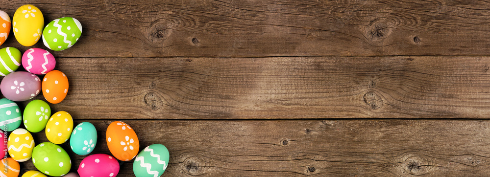 Poster colorful easter egg banner with corner border against a rustic old wood background. top view with co