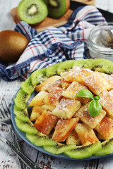 Austrian dessert Kaiserschmarrn served with sugar powder and kiwi fruit	