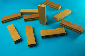 Scattered pieces of wood near one standing on a blue background, business concept, leadership, thinking differently