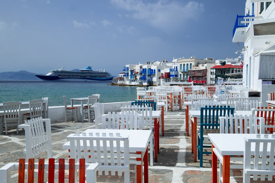 Outdoor restaurant with sea view near romantic colorful Little Venice at sunny day. Yachts on Aegean sea. Amazing touristic place, People walking along promenade, Alefkandra area. Greece vacation