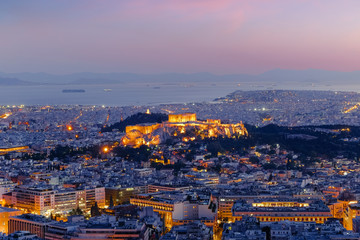 Fototapeta na wymiar Amazing aerial view of Athens, Greece. Night over ancient Acropolis, ruins. Parthenon, the Icon of the hellenic civilization, Aegean sea on background. Traditional mediterranean architecture 