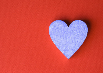 Obraz premium Wooden blue heart on a red background. Greeting card for Valentine's day. Declaration of love.